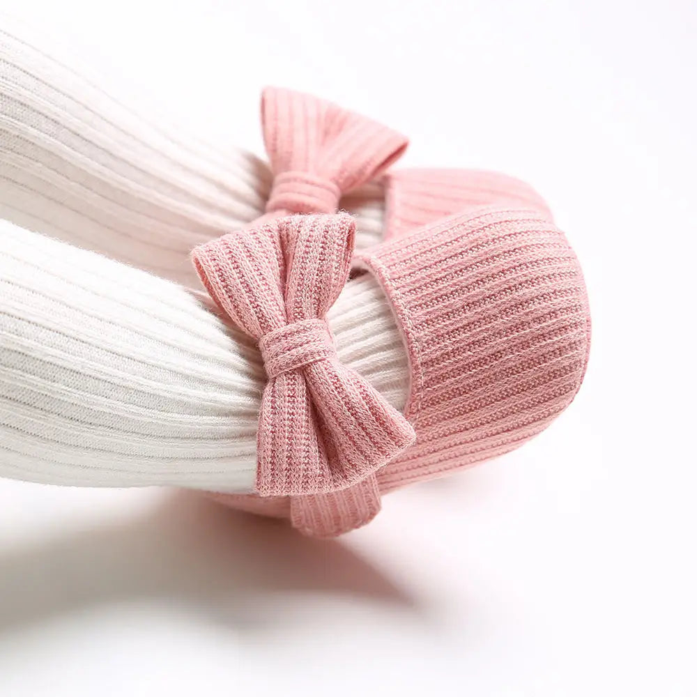 Pink knitted bow headband on a white background